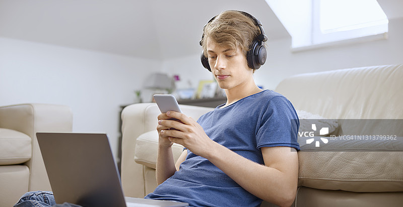 青少年男孩在客厅里使用智能手机图片素材