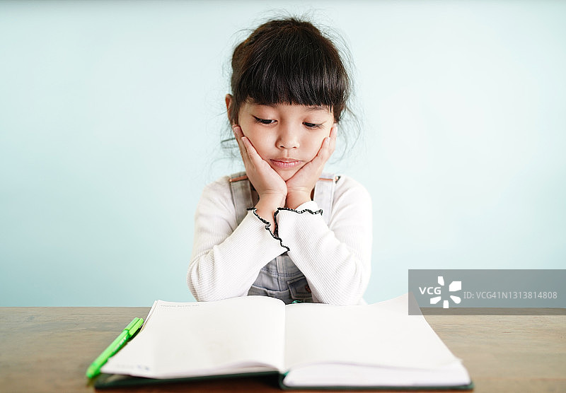 课业上的困惑：因家庭作业感到压力大的小女孩图片素材