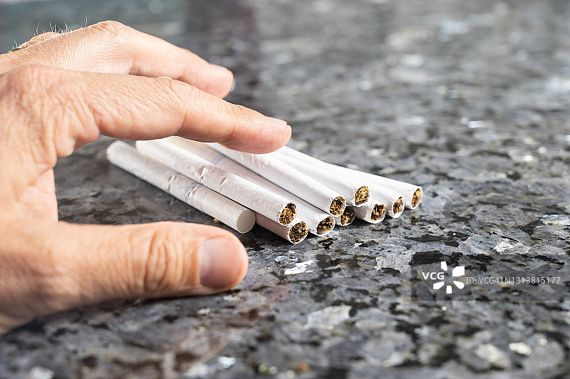 男人的手拿着桌上的香烟图片素材