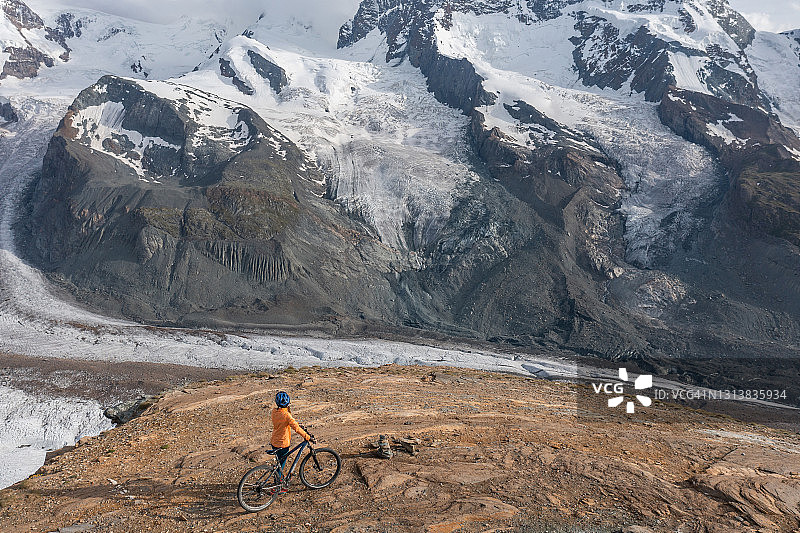 山地自行车手欣赏瑞士美丽的冰川图片素材