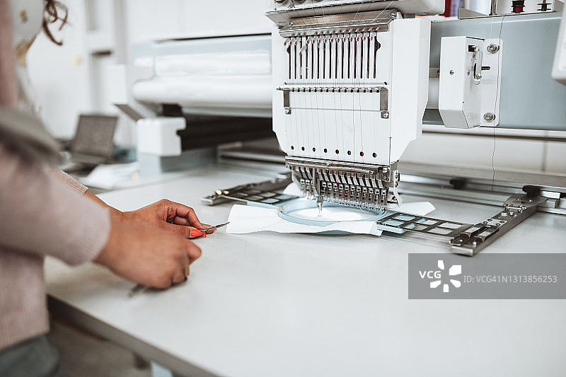 女人等待机器将线缝入布料图片素材