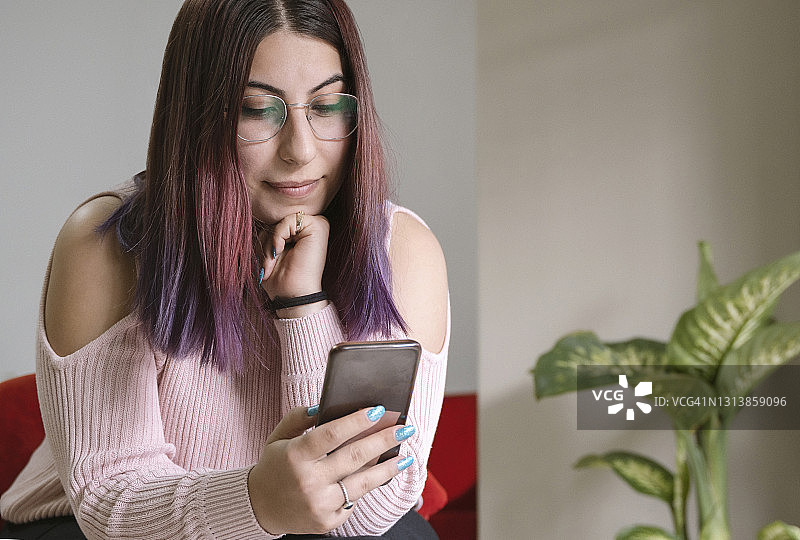年轻女人在家使用智能手机图片素材