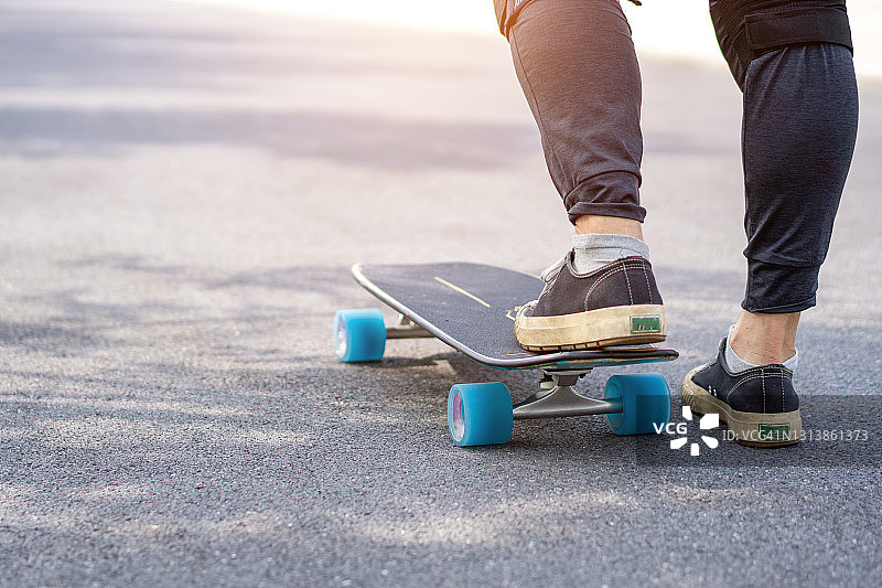 冲浪滑板运动生活方式特写，健康运动概念，疫情期间亚洲男子玩滑板的时尚瞬间图片素材