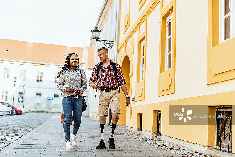 截肢男子与朋友在春季游览城市图片素材