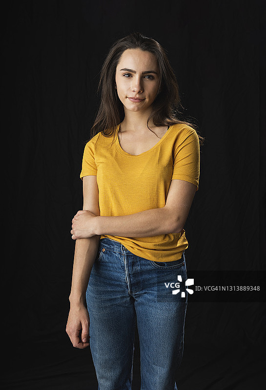 黑色背景下的年轻女子影棚肖像照图片素材