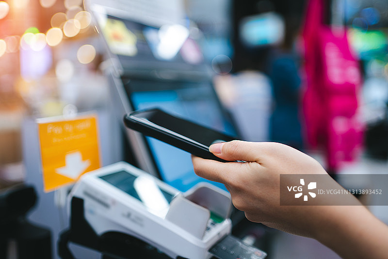 扫描二维码，在商店自助结账台用手机支付的局部图图片素材