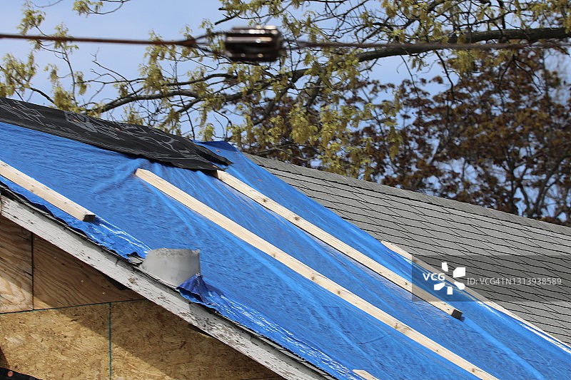 用塑料防水布覆盖屋顶的建筑维修工程图片素材