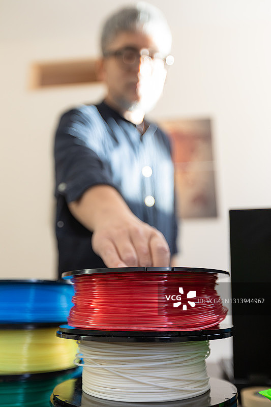 在小型企业办公室中使用3D打印机的人们图片素材