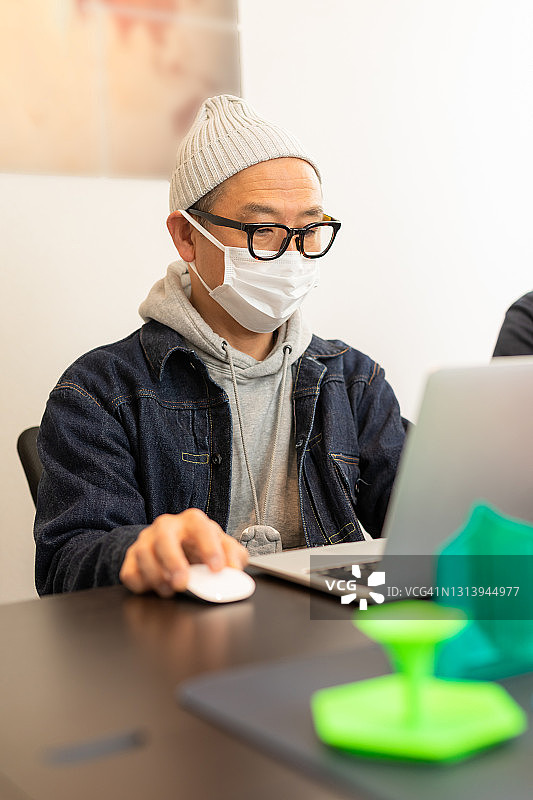 在小型企业办公室中使用3D打印机的人们图片素材