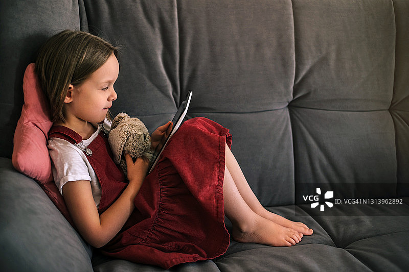 在家使用平板电脑的小女孩肖像图片素材