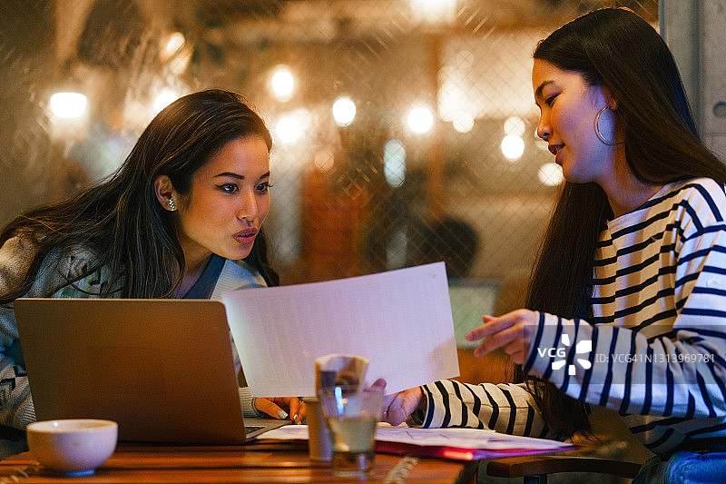 夜晚在咖啡馆一起工作的两个女人图片素材