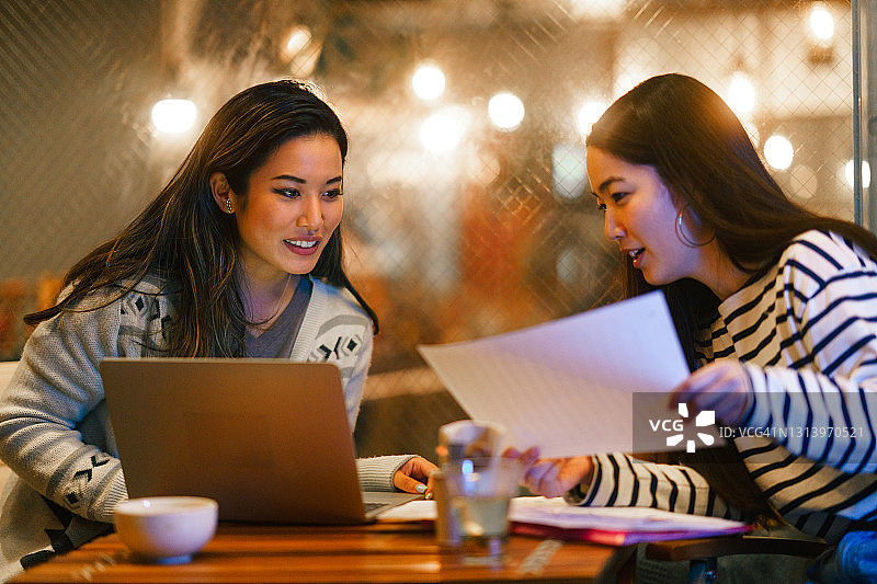 夜晚在咖啡馆一起工作的两个女人图片素材