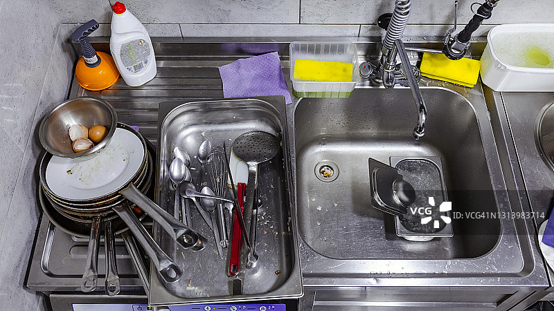 商业厨房中堆满餐具的水槽图片素材
