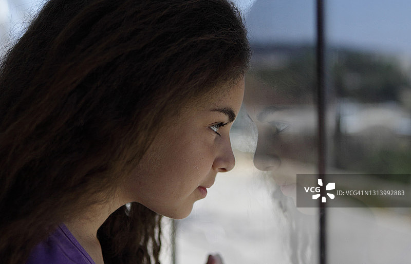 美丽的女孩在窗边看倒影图片素材