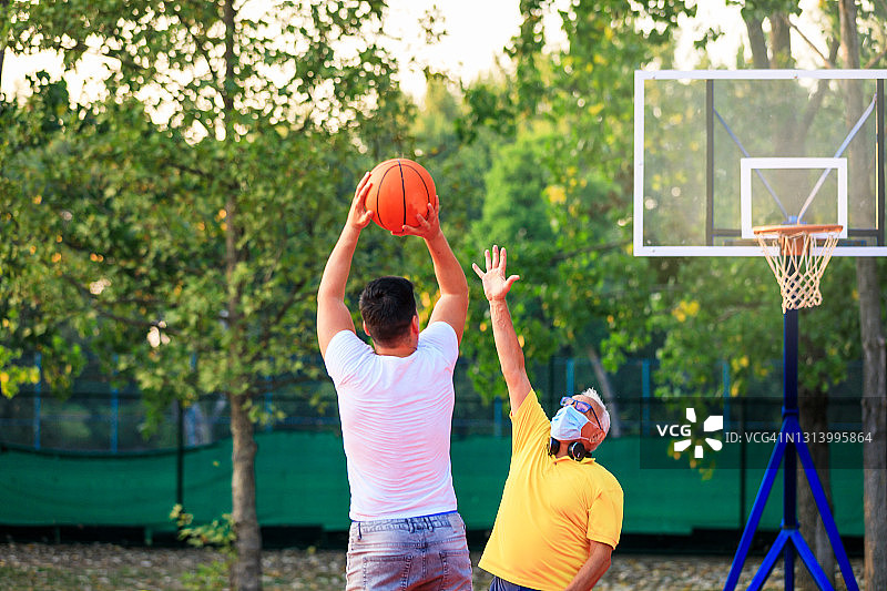 父子在公园里打篮球图片素材