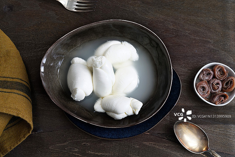 牛奶马苏里拉奶酪结，典型的坎帕尼亚产品和橄榄油凤尾鱼图片素材