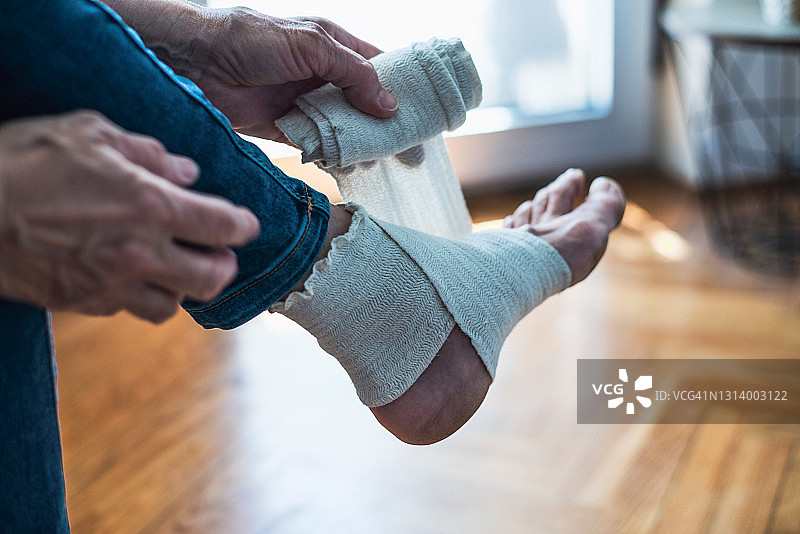 女人在腿上系绷带图片素材