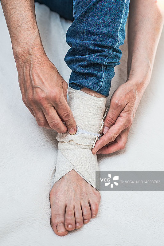 女人在腿上系绷带图片素材