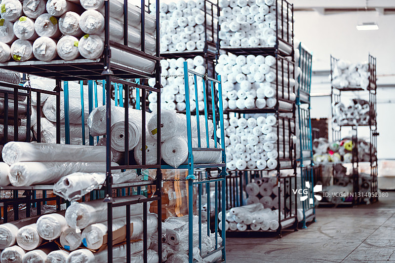 仓库男工微笑搬运布料卷图片素材