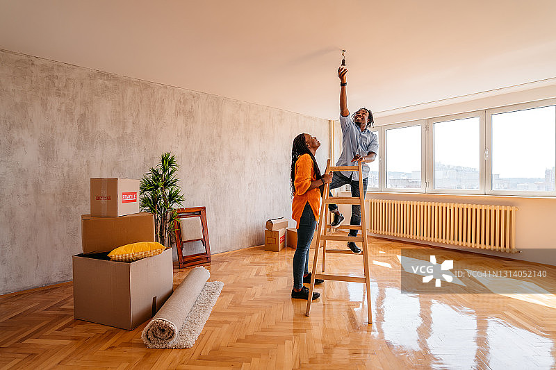 男人和女友一起搬家时更换灯泡图片素材