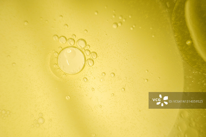 具有气泡的微距流体，抽象黄色背景。选择性聚焦。图片素材