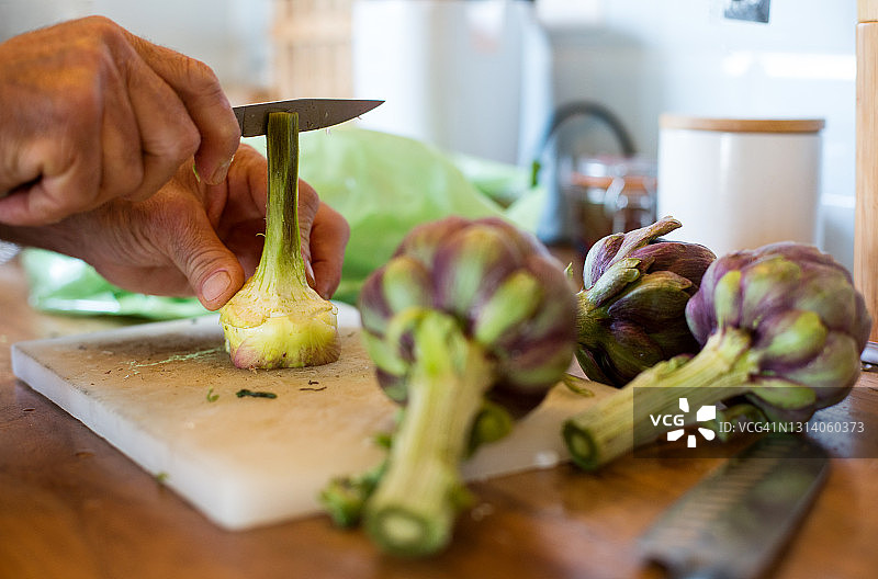 男人清洗并切新鲜朝鲜蓟，手部特写图片素材