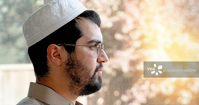 沉思的年轻男子看着窗外图片素材