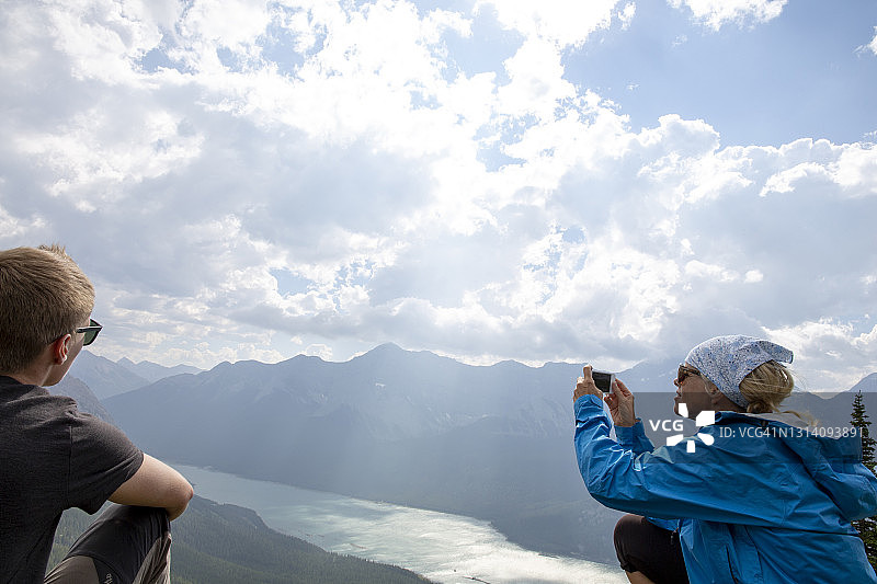徒步者在山脊上用手机拍照图片素材