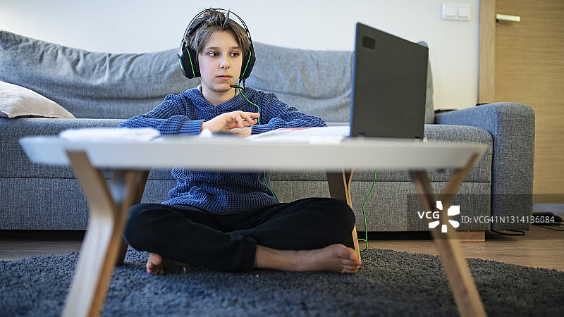在房间里参加在线课程的小男孩图片素材