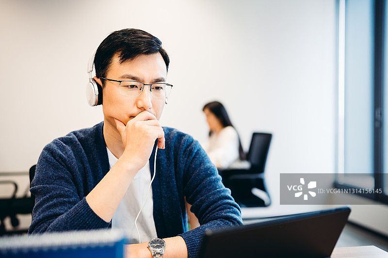 年长的亚洲男人在办公室用笔记本电脑进行视频通话图片素材