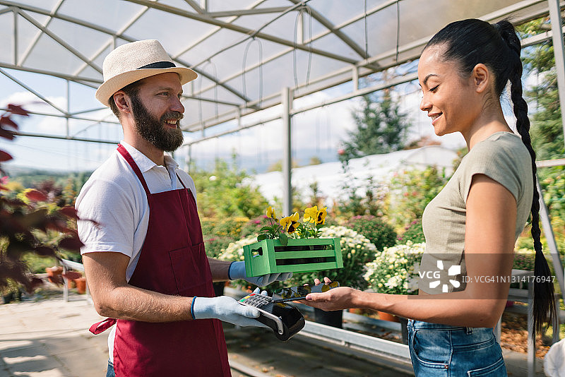 在花园中心购买鲜花的漂亮女人图片素材