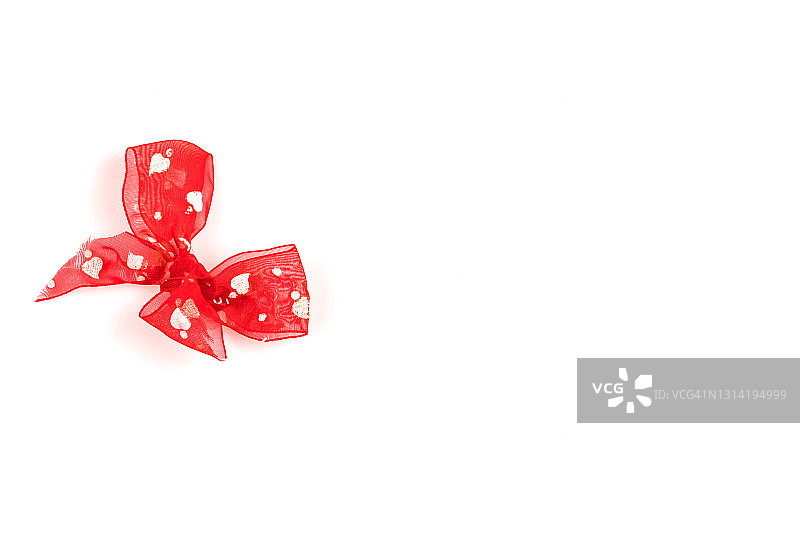 白色背景上带红心的红色蝴蝶结，情人节贺卡概念图片素材
