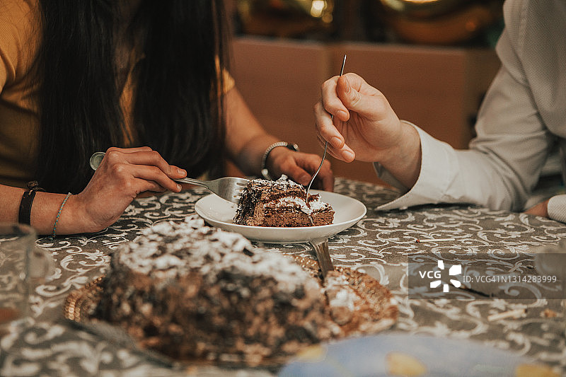 年轻情侣在咖啡馆分享巧克力蛋糕图片素材