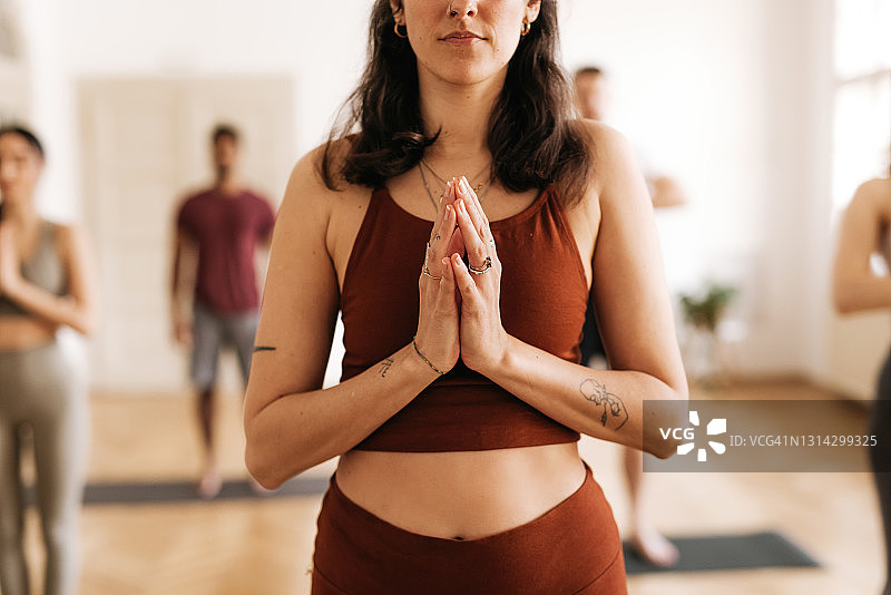 运动型年轻女子以祈祷姿势做山式瑜伽图片素材