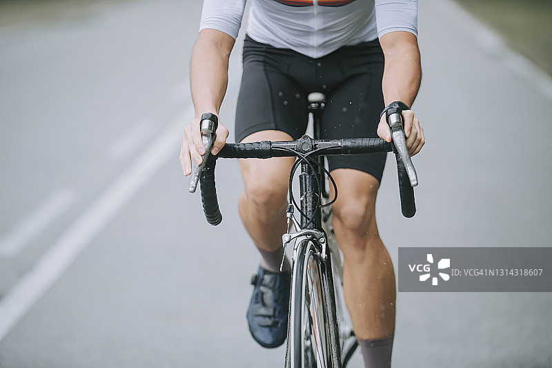 中国自行车运动员在乡村地区雨中骑行图片素材