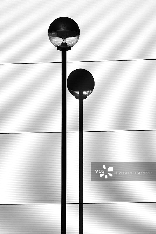 现代街灯和灰色墙壁阴影的高对比度图片素材