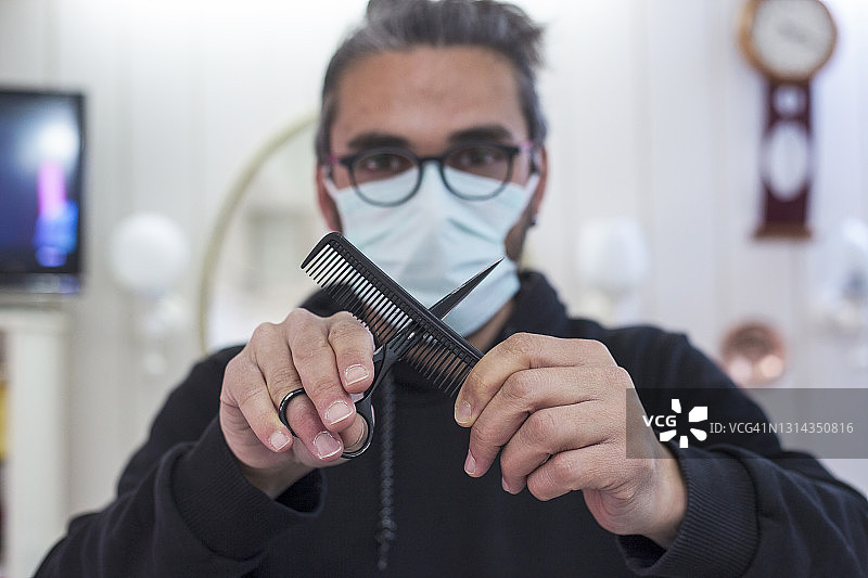 时尚发型师手持梳子和剪刀的特写图片素材