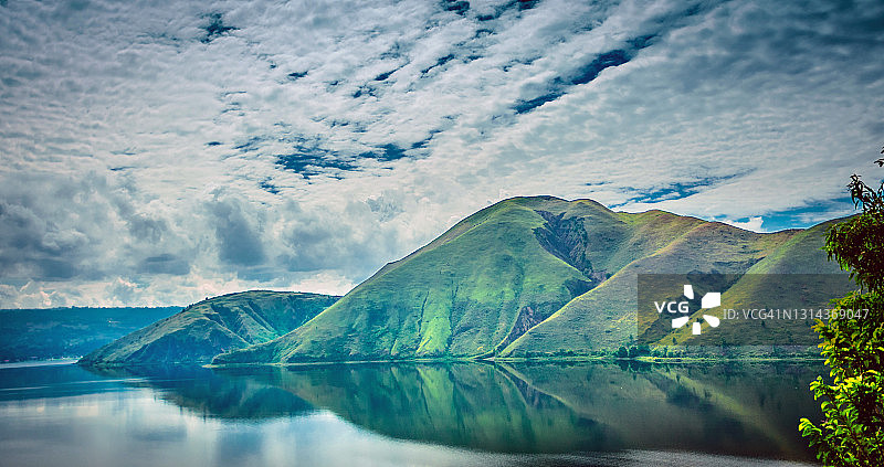 多巴湖中的山丘倒影图片素材