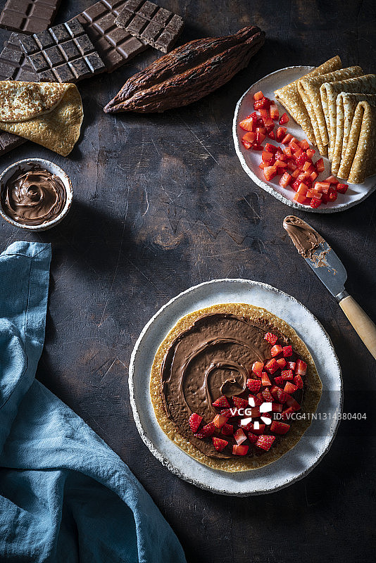 黑木背景：可可巧克力草莓纯素可丽饼图片素材
