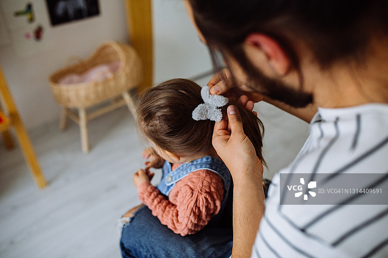 负责任的父亲给女儿编辫子，准备上学图片素材