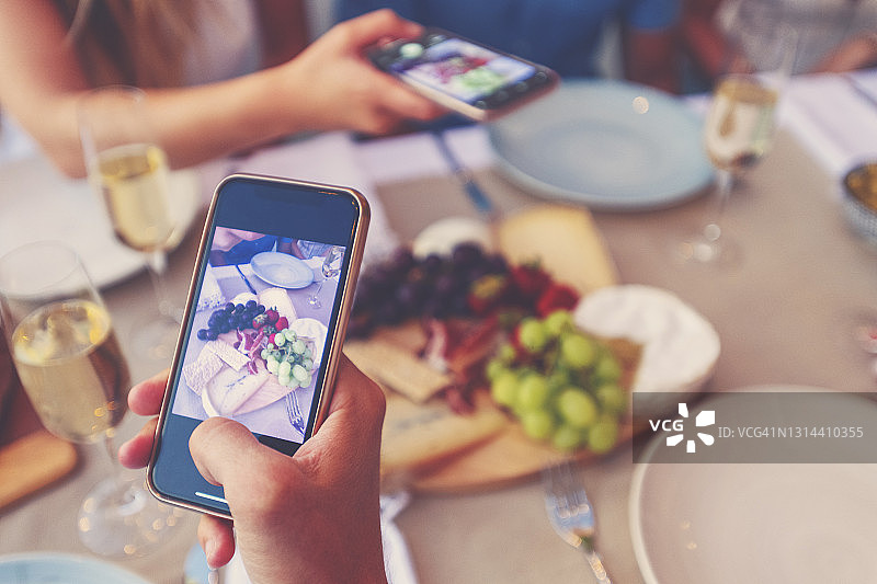 朋友聚餐用手机拍美食香槟图片素材