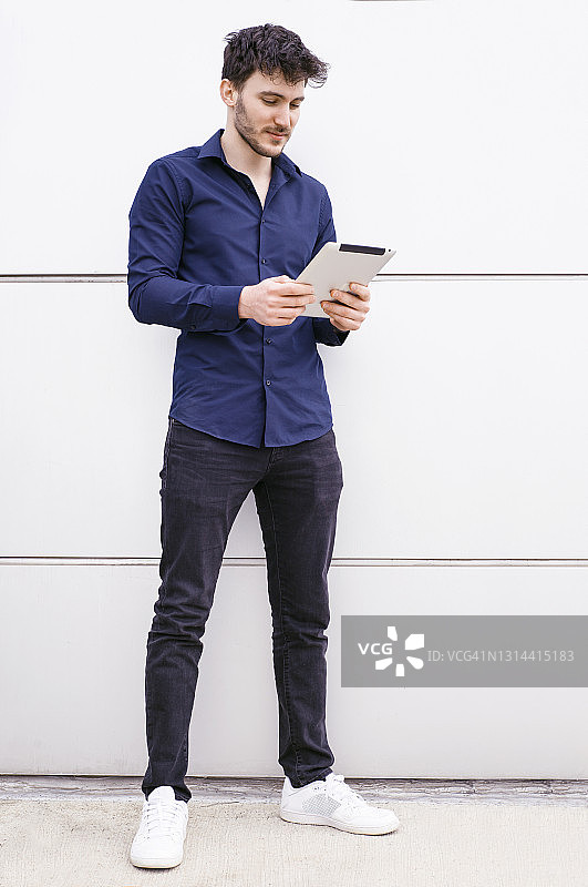 在户外用平板电脑进行视频通话的年轻男子图片素材