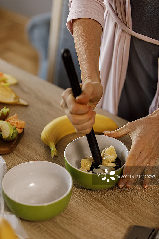 女人正在捣碎香蕉，准备零食图片素材