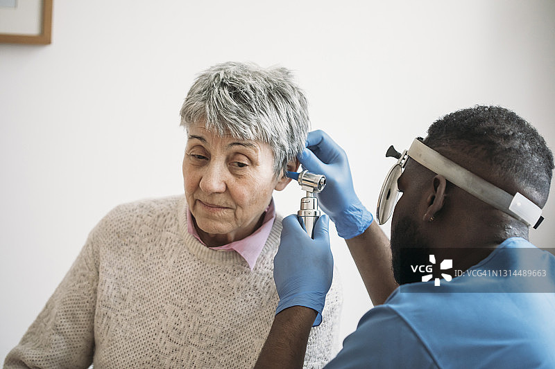 一位年长的女人正在让耳科医生检查耳朵图片素材