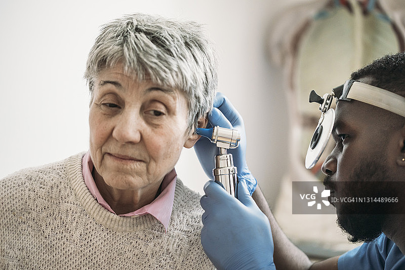 医生在常规体检中检查年长妇女的耳朵图片素材
