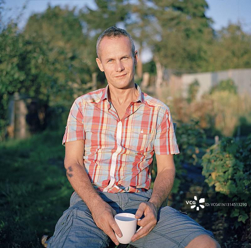 男人坐在他的菜园里图片素材