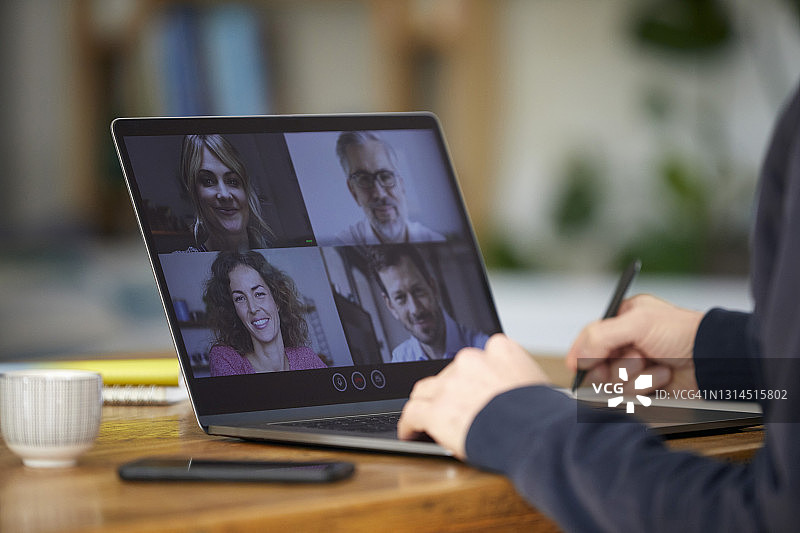 在与同事进行视讯会议时写作和规划的男商人图片素材