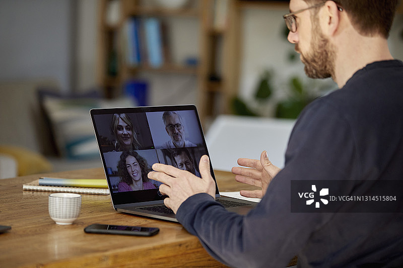 年长的商人通过笔记本电脑与同事进行视频通话图片素材