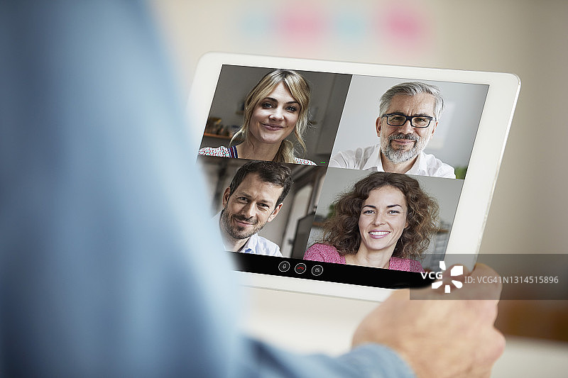 在办公室通过平板电脑参加视频会议的商人图片素材