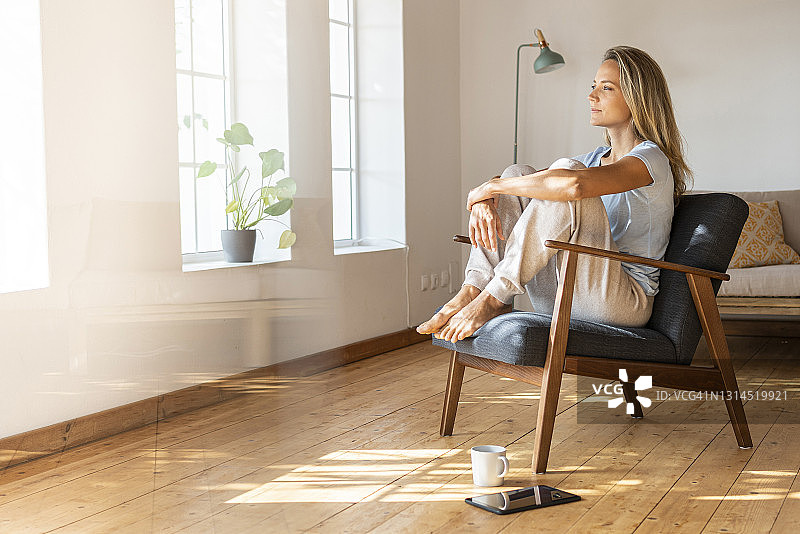 女人在家坐在椅子上做白日梦图片素材